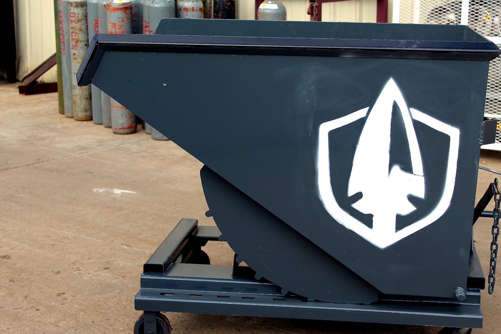 Self-dumping hopper painted with the white Spartan shield logo