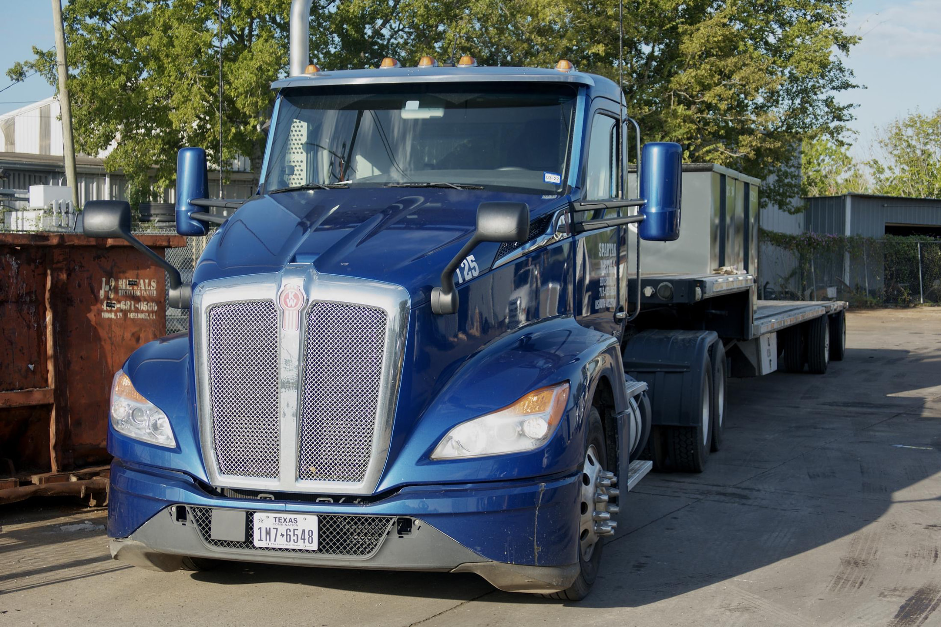 Spartan Metals truck 125 with its flatbed trailer in the Houston yard